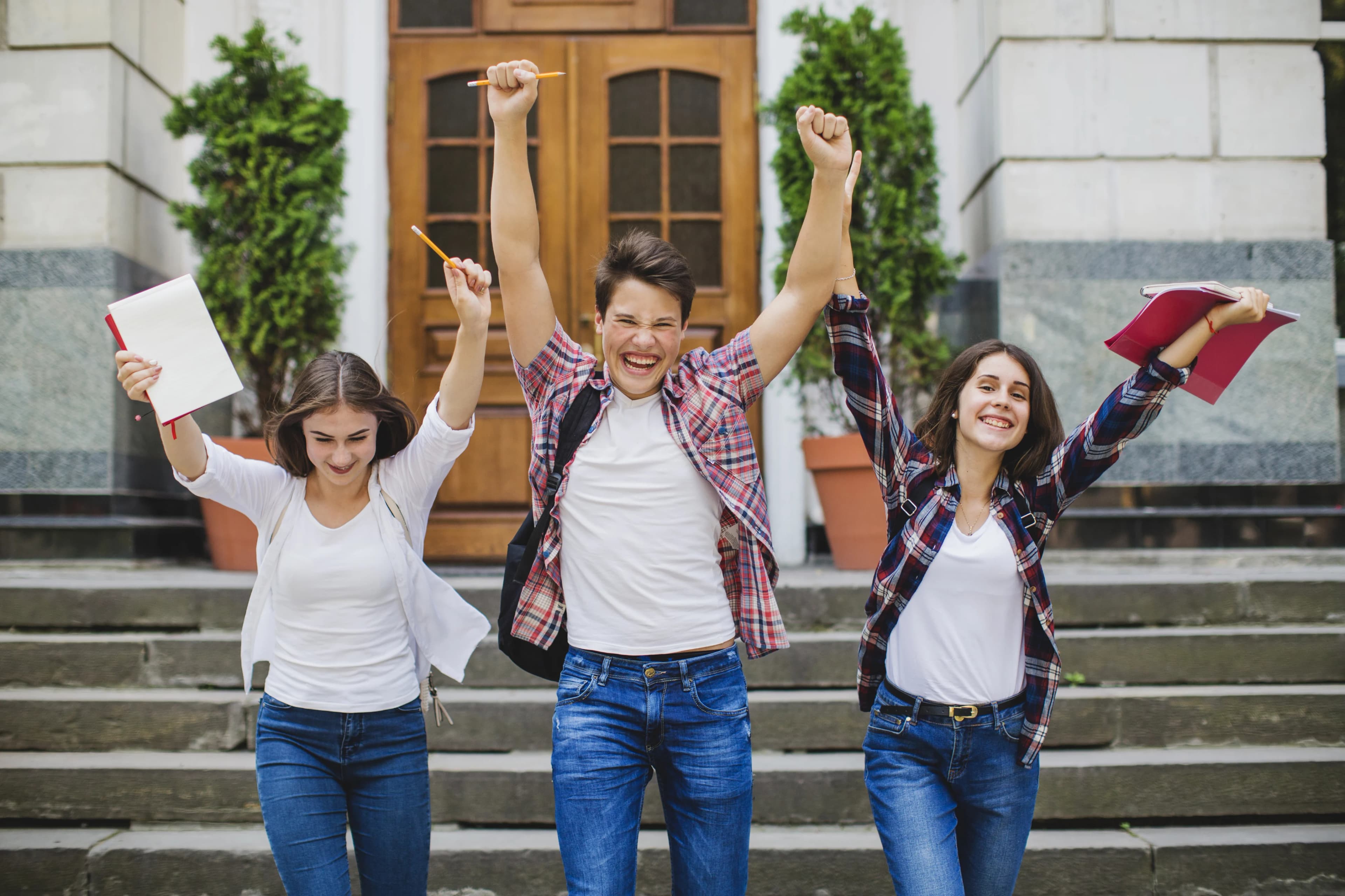 Students cheering with study materials